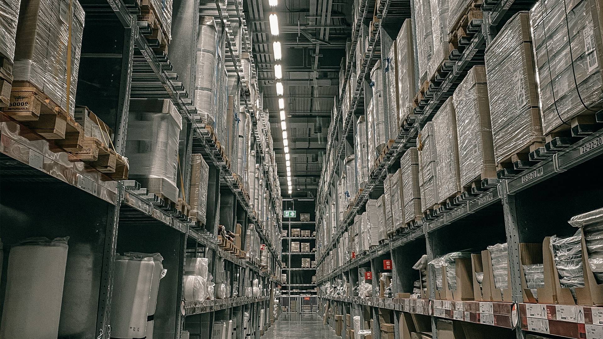 Long aisle of racked and palletised goods inside a distribution warehouse