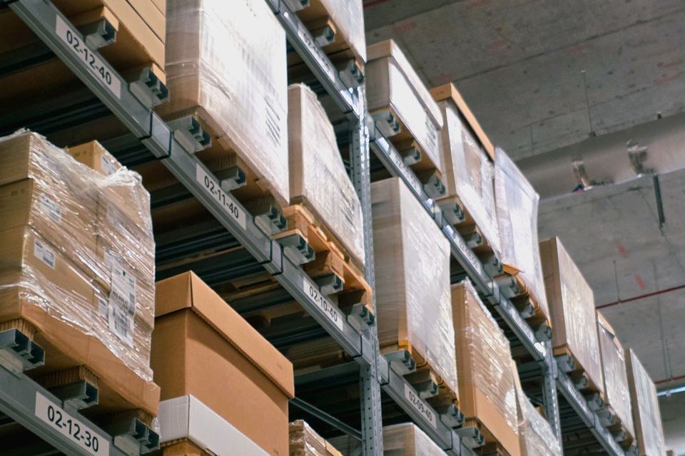 Cartons and shrink-wrapped goods stacked on warehouse racking